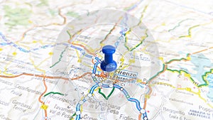 A blue board pin stuck in Florence on a map of Italy photo