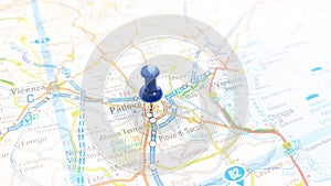 A blue board pin stuck in Padova on a map of Italy photo