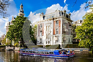 Blue boat company canal trip in Amsterdam city, Netherlands