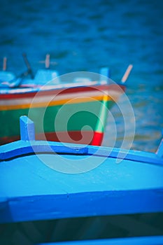 Blue boat detail with blurred sea and another boat in the background