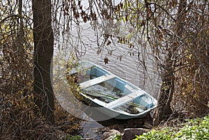 Blue boat on the natural lake in autumn forest