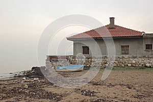 Blue boat next to seaside house