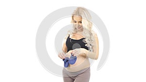 Blue booties on background pregnant belly, white