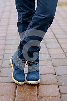 Blue boots on men`s legs in blue jeans