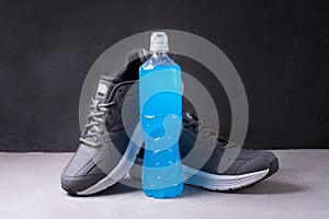 Blue bottle of isotonic drink to recover water and salt balance after training on a black background