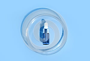 Blue bottle. Laboratory glass petri dish with pipette of water, serum, oil, beauty product. Natural medicine