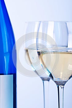 Blue bottle of white wine and two wine glasses