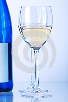 Blue bottle of white wine and two wine glasses