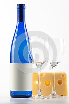 Blue bottle of white wine, two wine glasses and ch