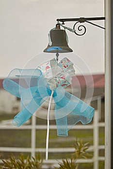 Blue bow hanging from a bell