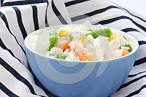 Blue bowl with cooked rice with mixed vegetable