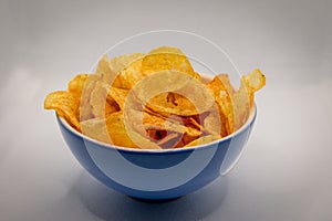 A blue bowl filled with crispy and spicey chips