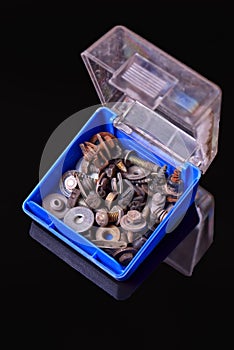 Blue box with old rusty bolts, screws, brackets, various metal details on black background