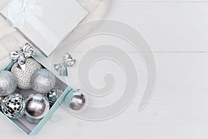 Blue box with silver Christmas balls on the white background, mock up, copy space