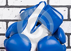 Blue boxing gloves, close-up, front view on a brick wall background