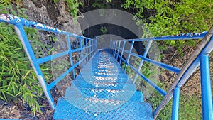 Blue bridge for adventures in a dark cave. For tourists like excitement. photo