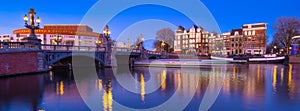 Blue bridge, Amsterdam, Netherlands. Blauwbrug. Evening cityscape. Blue sky and city lights. Dutch canals.