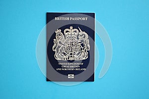 Blue British passport on blue background close up