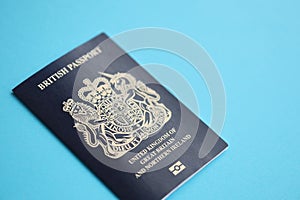 Blue British passport on blue background close up