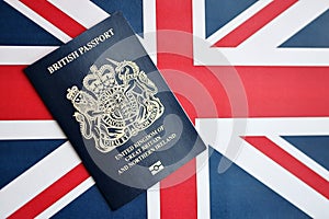 Blue British passport on national flag background close up