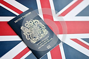 Blue British passport on national flag background close up