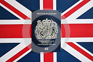 Blue British passport on national flag background close up