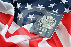 Blue British passport on United States national flag background close up