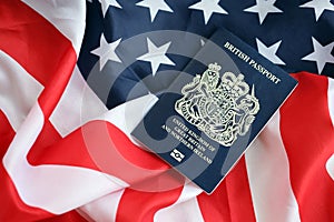 Blue British passport on United States national flag background close up