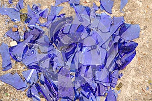 Blue broken glass on a concrete surface - texture for a background, design