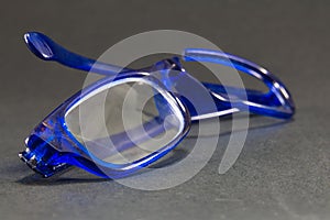 Blue broken glasses on black background