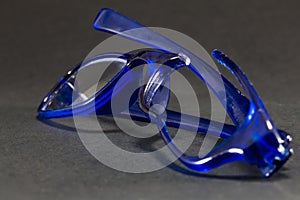 blue broken glasses on black background