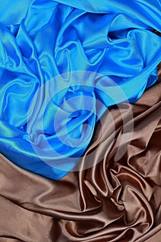 Blue and brown silk satin cloth of wavy folds texture background