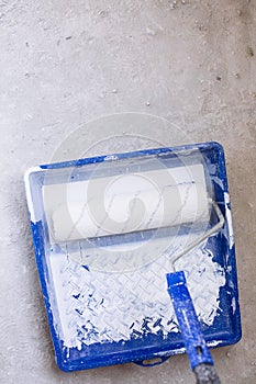 Blue bucket with paint and a brush roller paint tray