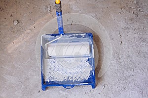 Blue bucket with paint and a brush roller paint tray