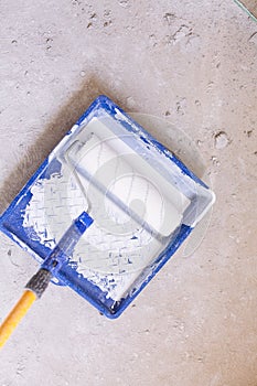 Blue bucket with paint and a brush roller paint tray