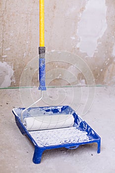 Blue bucket with paint and a brush roller paint tray