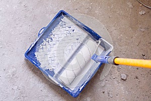 Blue bucket with paint and a brush roller paint tray