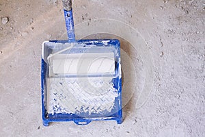 Blue bucket with paint and a brush roller paint tray