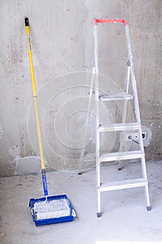 Blue bucket with paint, brush roller paint tray and ladder