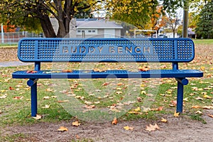 Blue buddy bench in the park in autumn