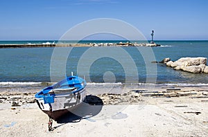 Blue burnt boat on the seashore Bari, Italy