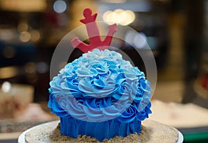 Blue buttercream cake with red anchor in front of cake-store