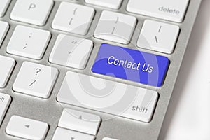 Blue button Contact Us on a white keyboard