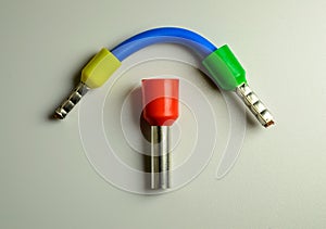 Blue cable with yellow and green ferrules and big red ferrule in the middle of composition.