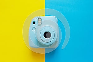 Blue camera with blank picture frames on colourful background. Fashion Film Camera. Nostalgia photography. Top view. Minimal and m