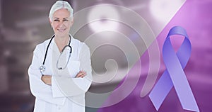 Blue cancer awareness ribbon and smiling caucasian mature female doctor standing with arms crossed