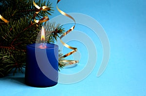 Blue candle lit on holiday christmas background