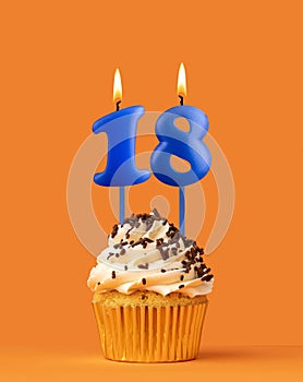 Blue candle number 18 - Birthday cupcake on orange background