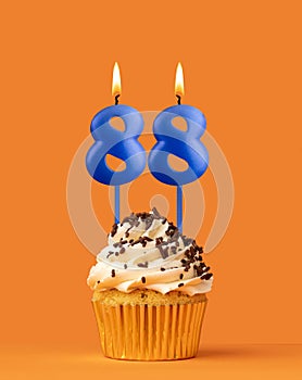 Blue candle number 88 - Birthday cupcake on orange background