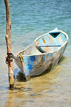 Blue canoe tied to pole